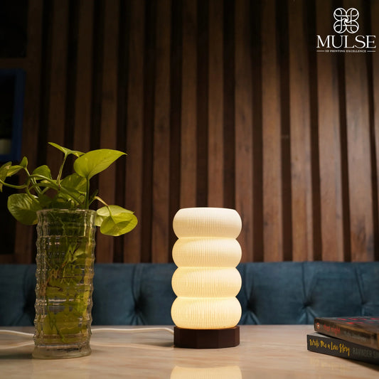 Modern 3D printed table lamp with ribbed design, lit on a marble surface next to a plant vase